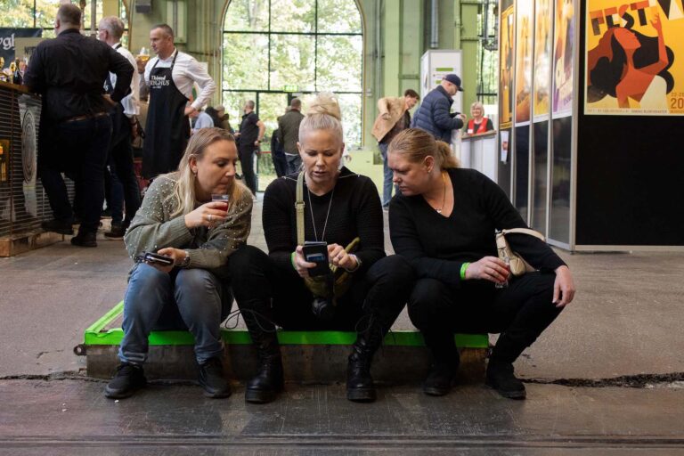 Tre personer kigger på mobiltelefon